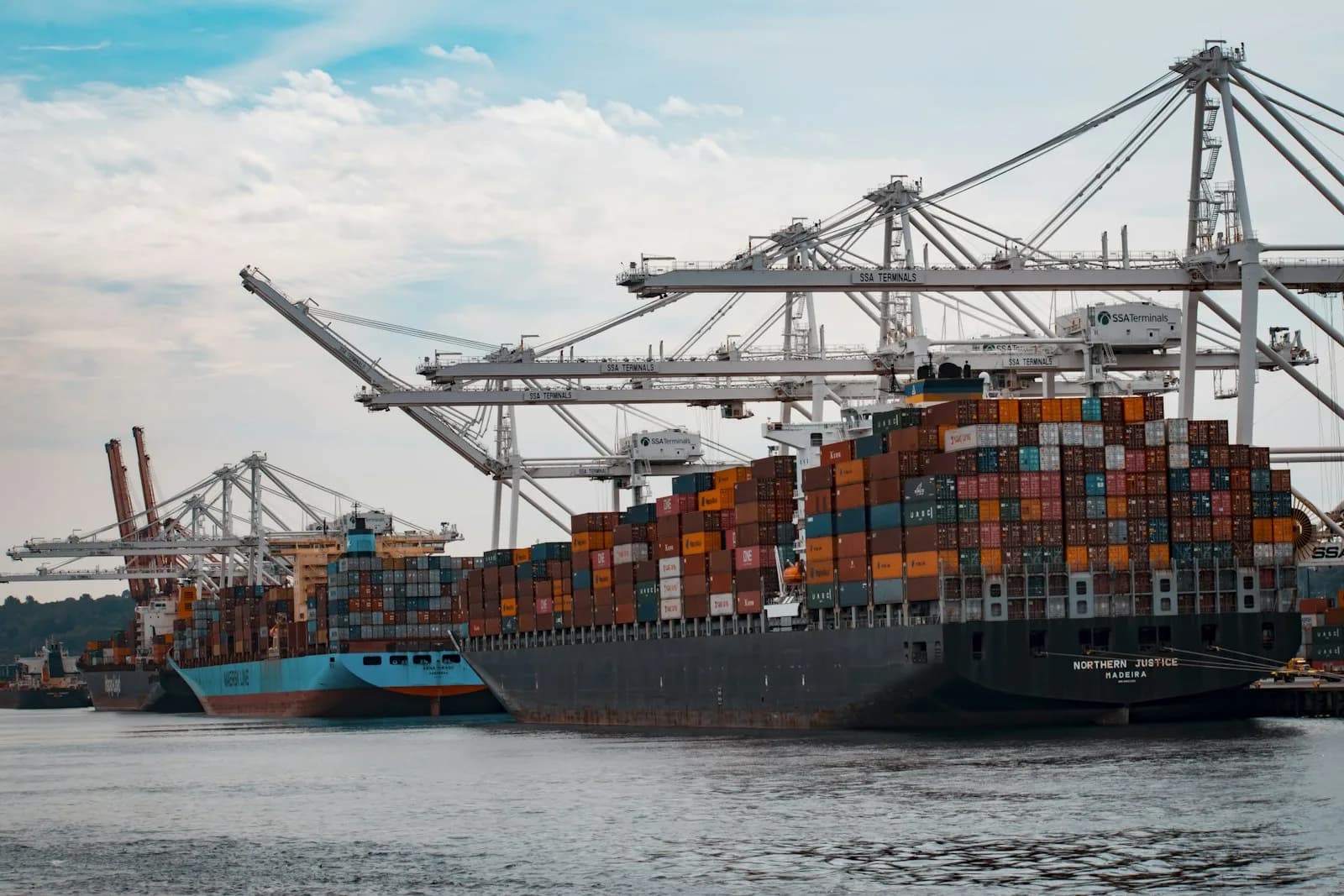 Container vessels working under quay cranes at berth