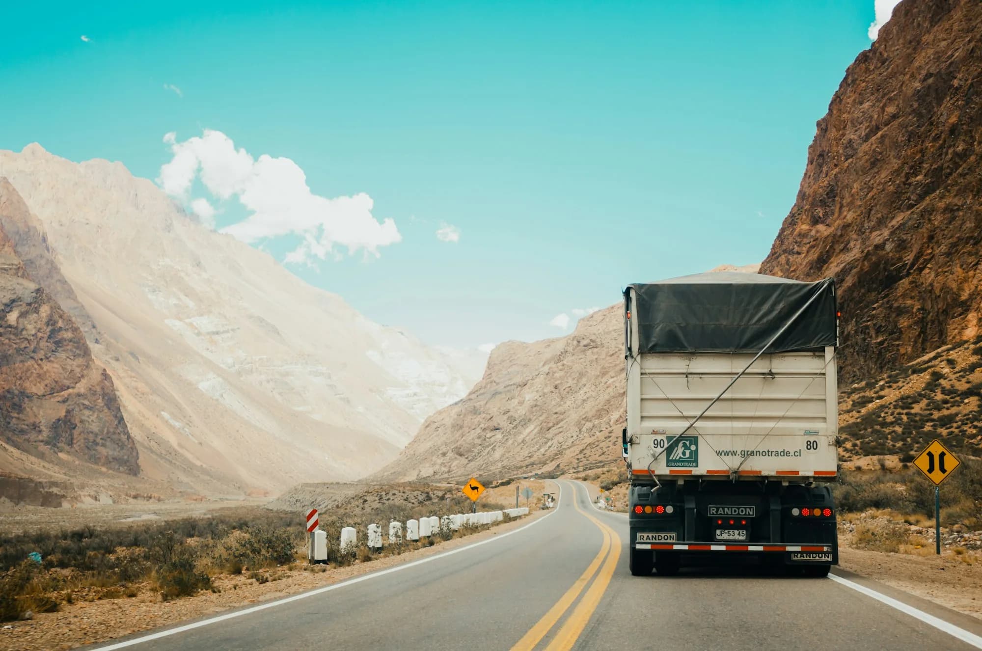Heavy haulage moving through a desert mountain corridor