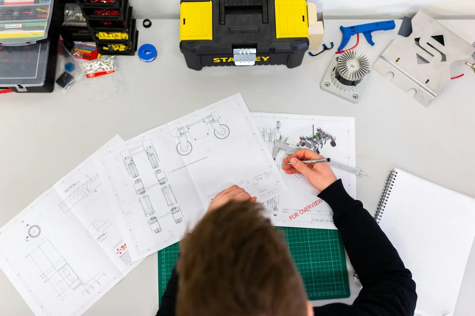 Technician verifying component dimensions against engineering drawings