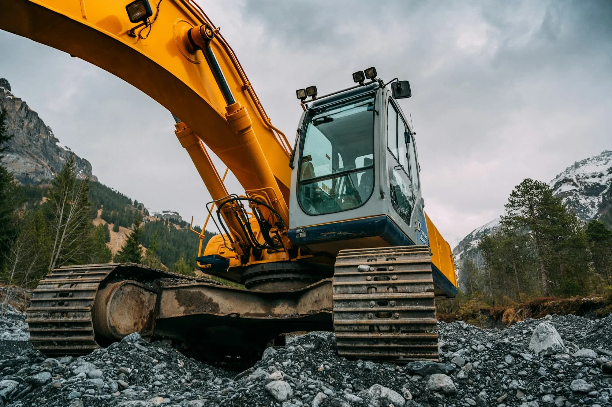 Tracked excavator staged on graded rock, ready for dispatch