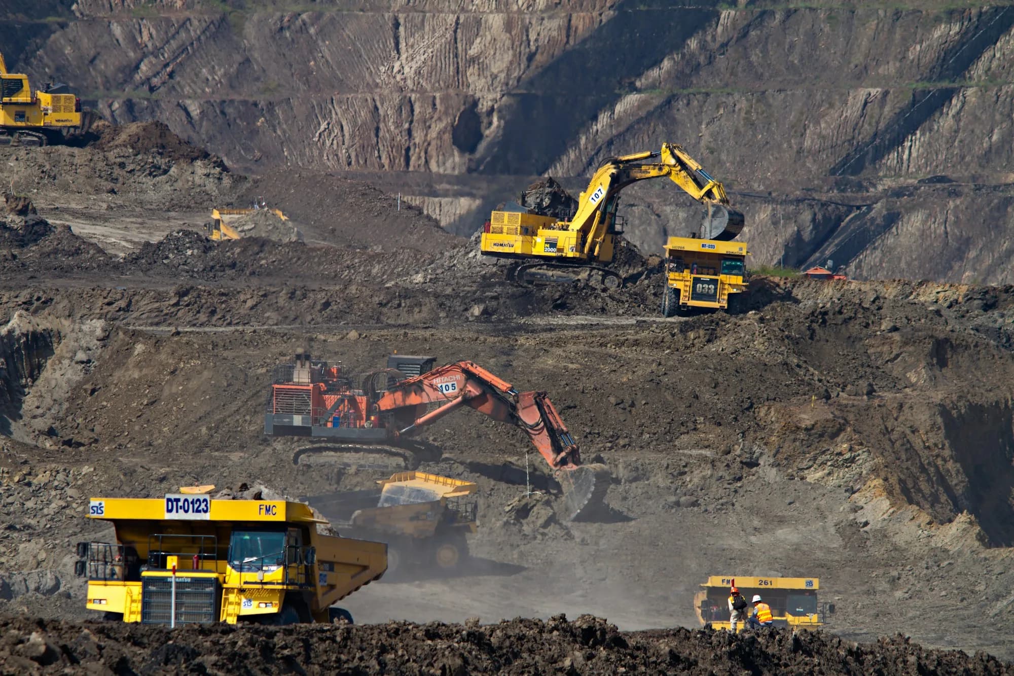 Haul trucks and excavators working benches on a bulk-earth operation